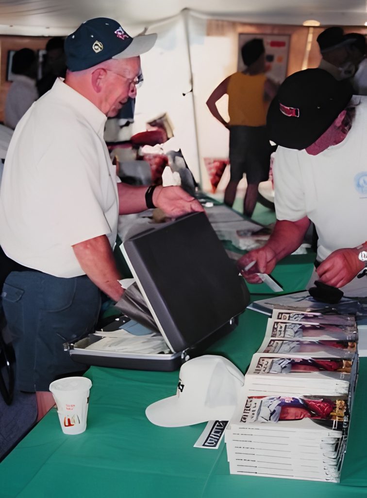 Men browsing documents at event table with brochures