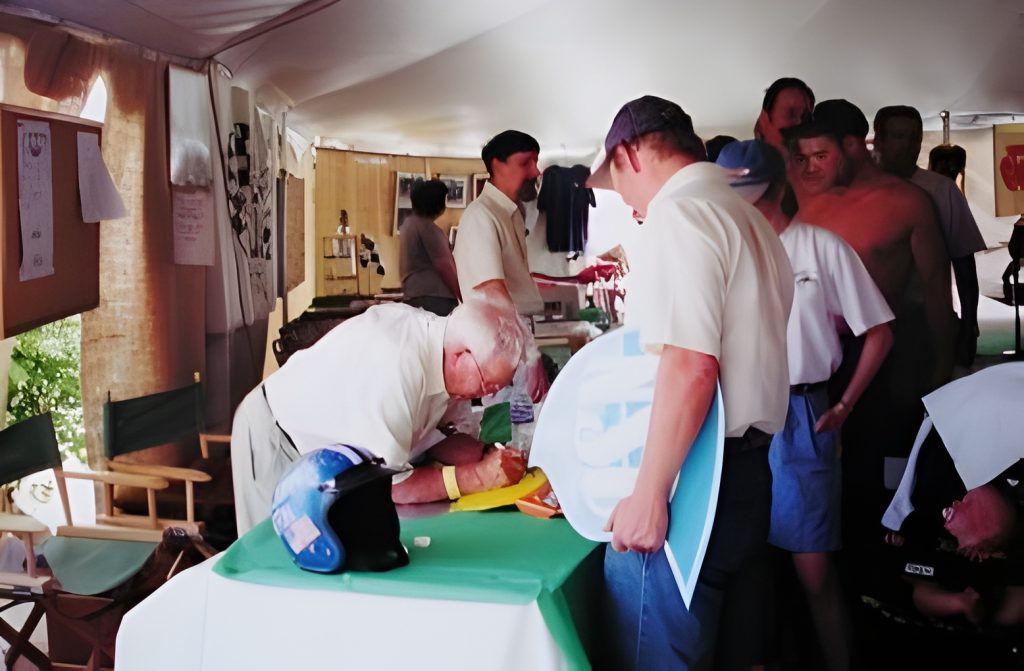 People gathered around a table in a tent.