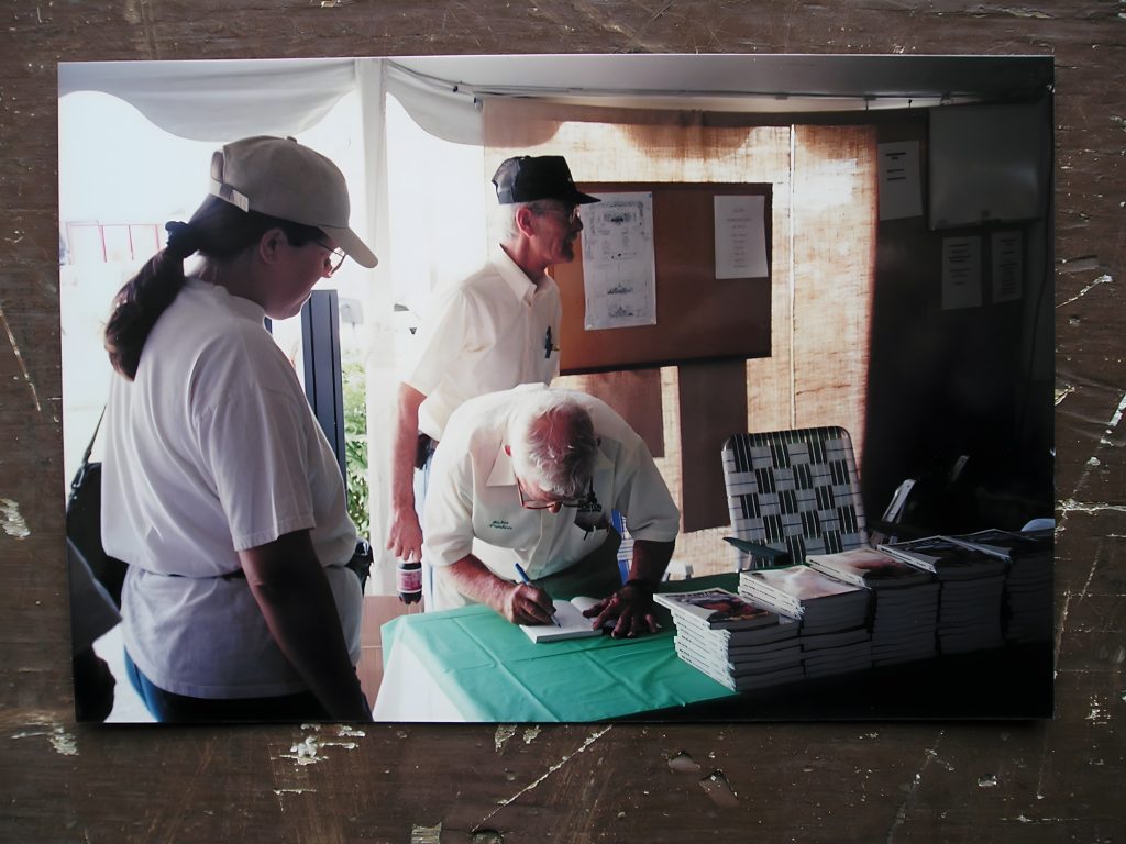 Man signing books at a signing event
