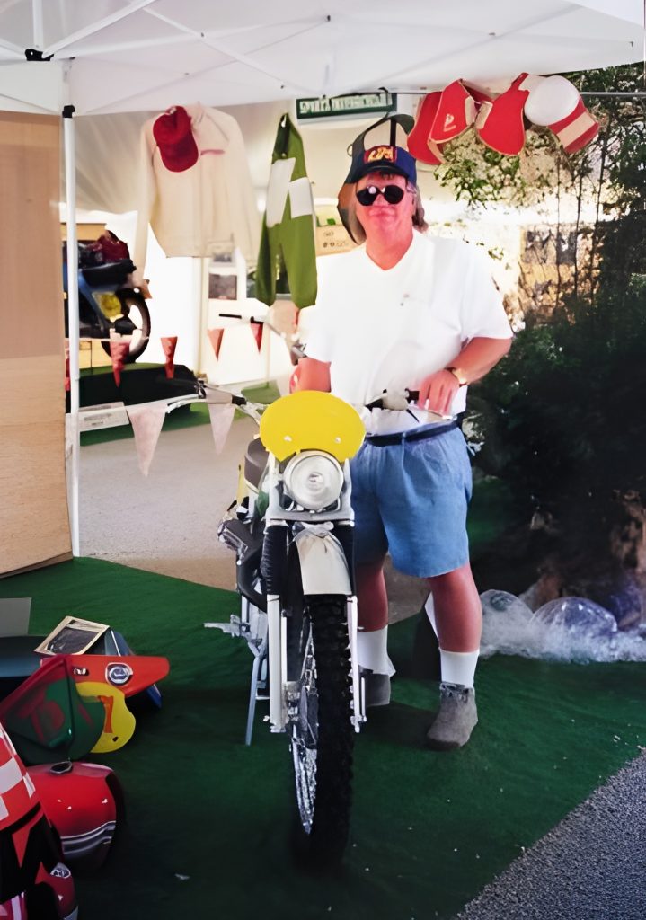 Person standing with vintage motorcycle at booth