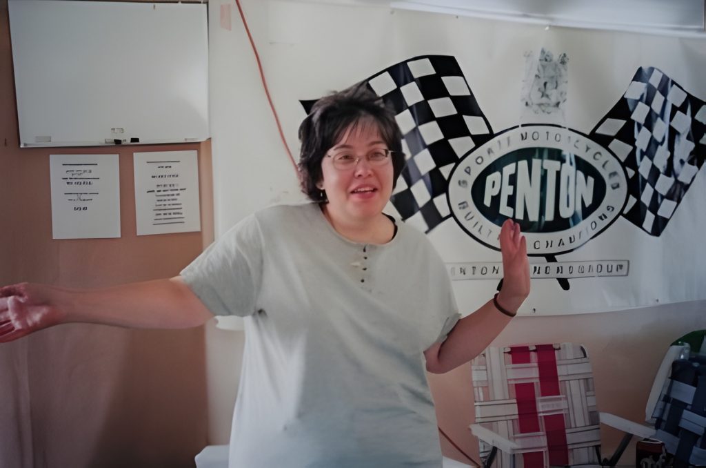 Person in front of Penton motorcycle banner.