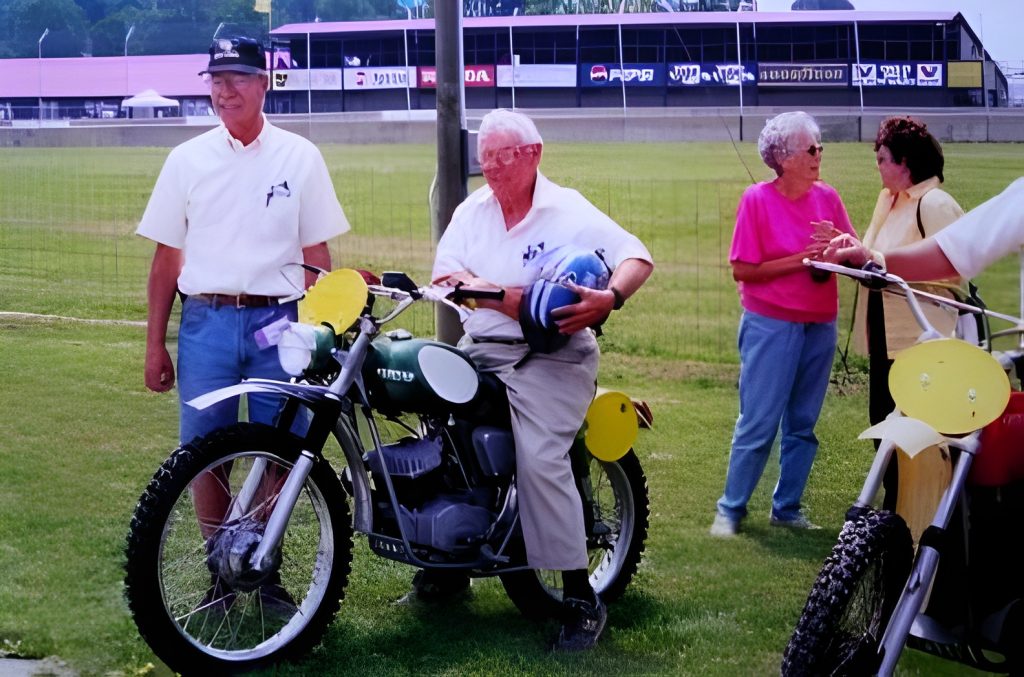 Elderly man on vintage motorcycle at the racetrack.