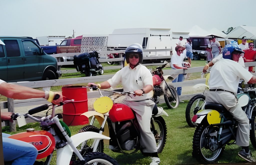 People riding vintage motorcycles at an outdoor event.