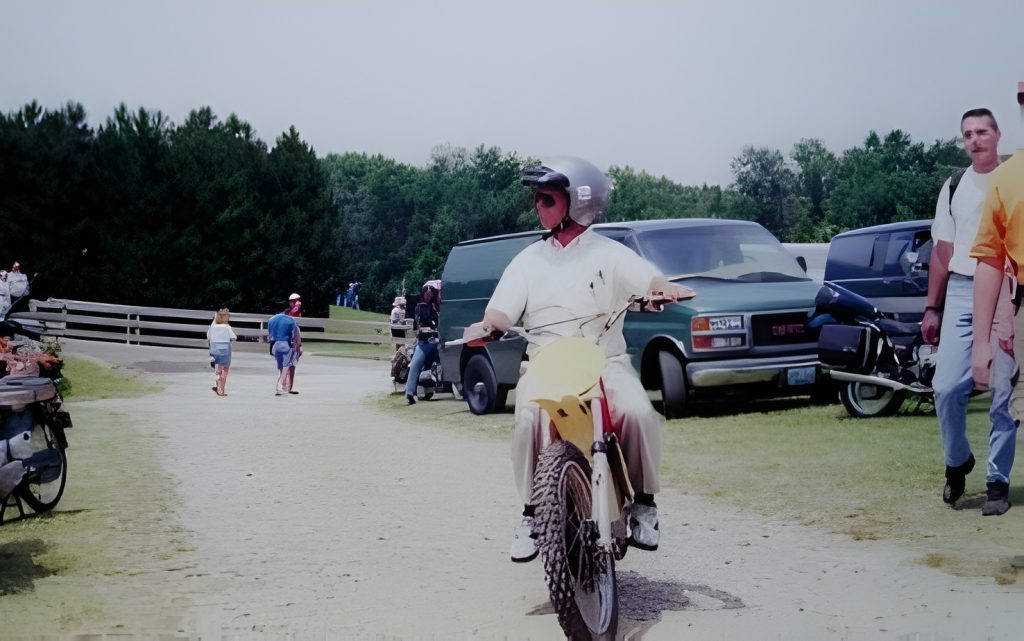 Person riding a dirt bike on a gravel path.
