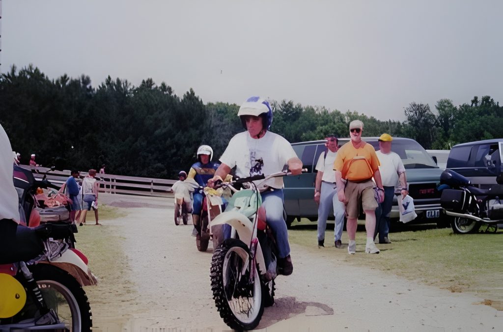 People riding off-road motorcycles in a park.