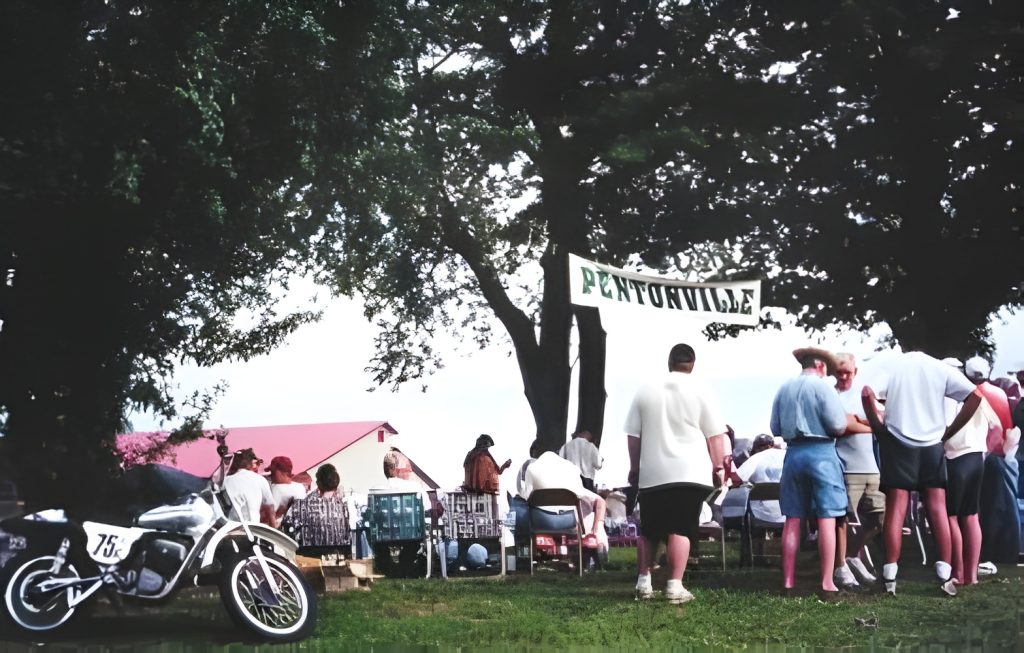 People gather at motorcycle event under Pentonville banner.