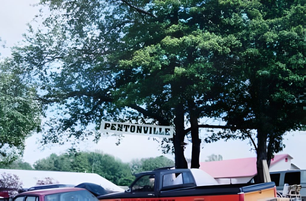 Pentonville sign hanging among trees with parked cars