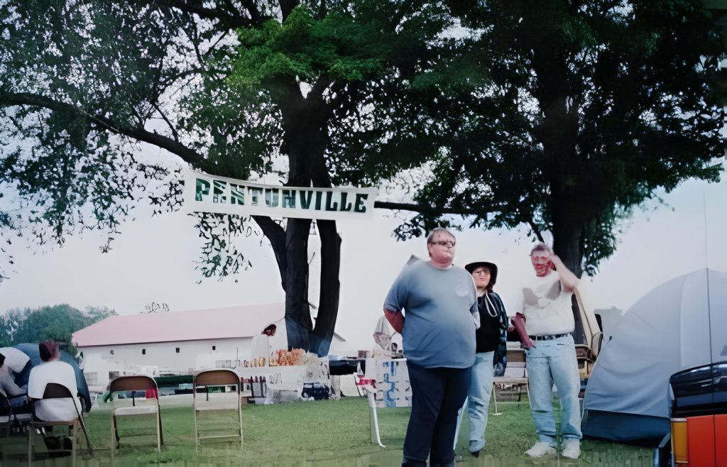 Outdoor event with people and PENTONVILLE sign.