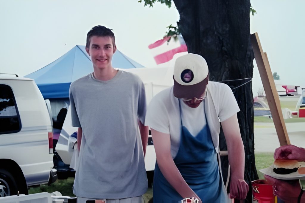 Two people at outdoor food stall event.