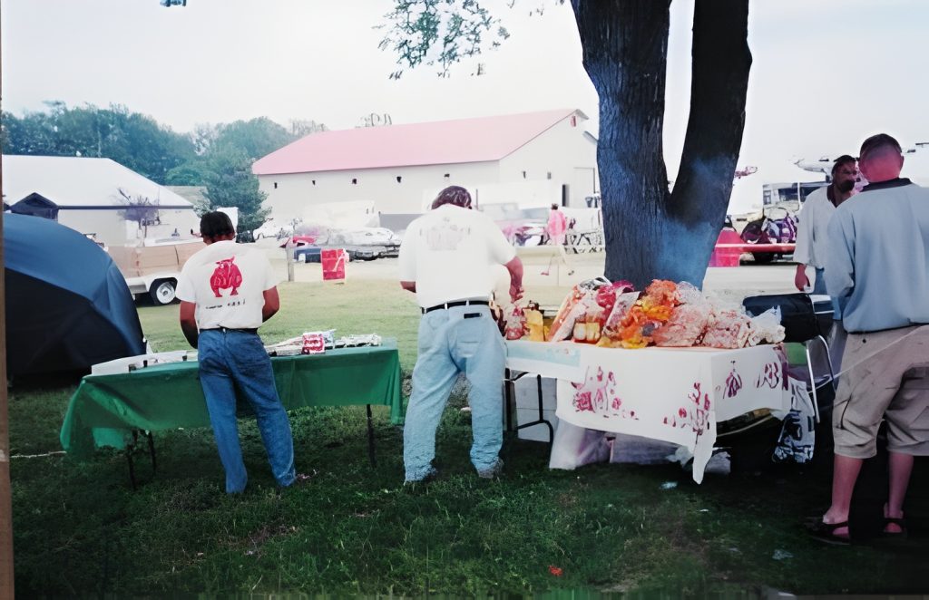 Outdoor barbecue event with people cooking food.