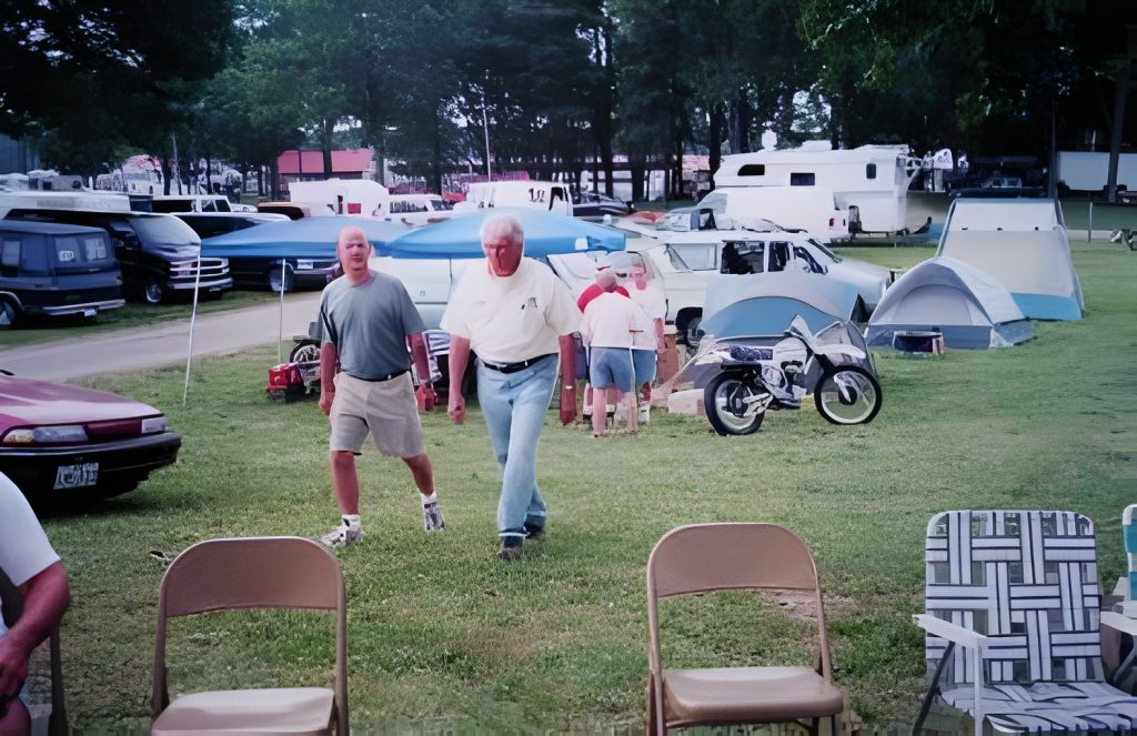 Men walking at a campsite with tents