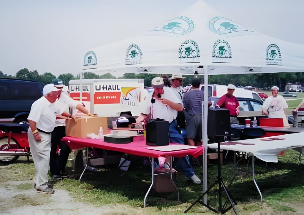 Outdoor event with canopy and people setting up.