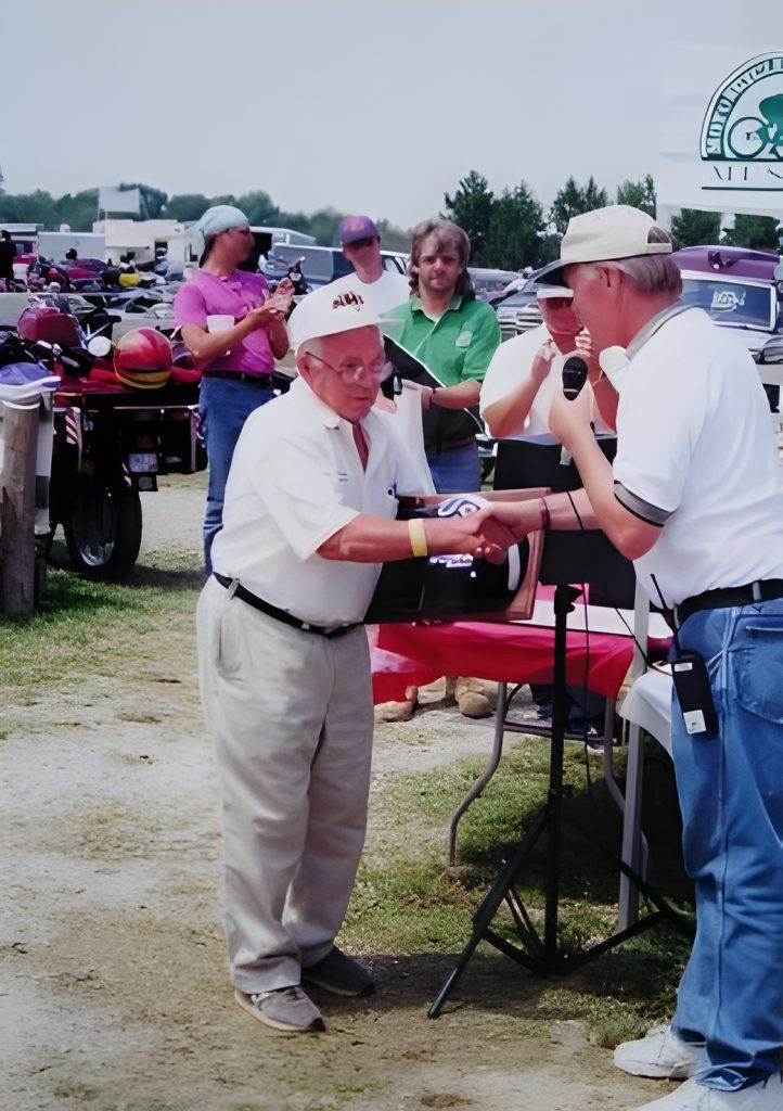 Man receiving award at outdoor event