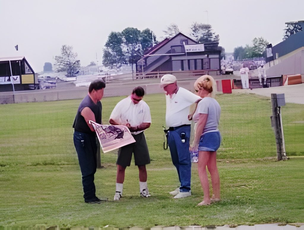 Group reviewing a map outdoors on grass field.