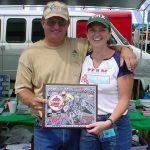 Couple smiling holding a motorcycle event award.