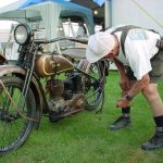 Man inspecting vintage Harley Davidson motorcycle