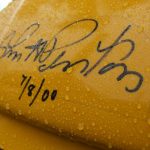 Close-up of autograph on yellow background with raindrops.