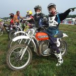 Motorcyclists on dirt track, preparing for race.
