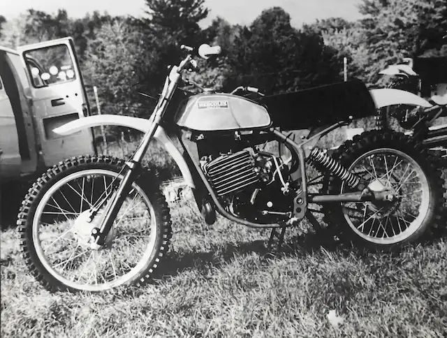 Vintage motorcycle parked in grassy area, black and white.