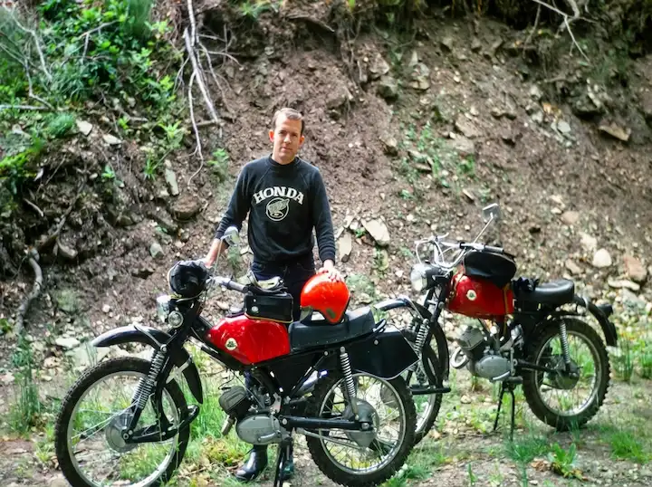 Person with vintage red motorcycles outdoors
