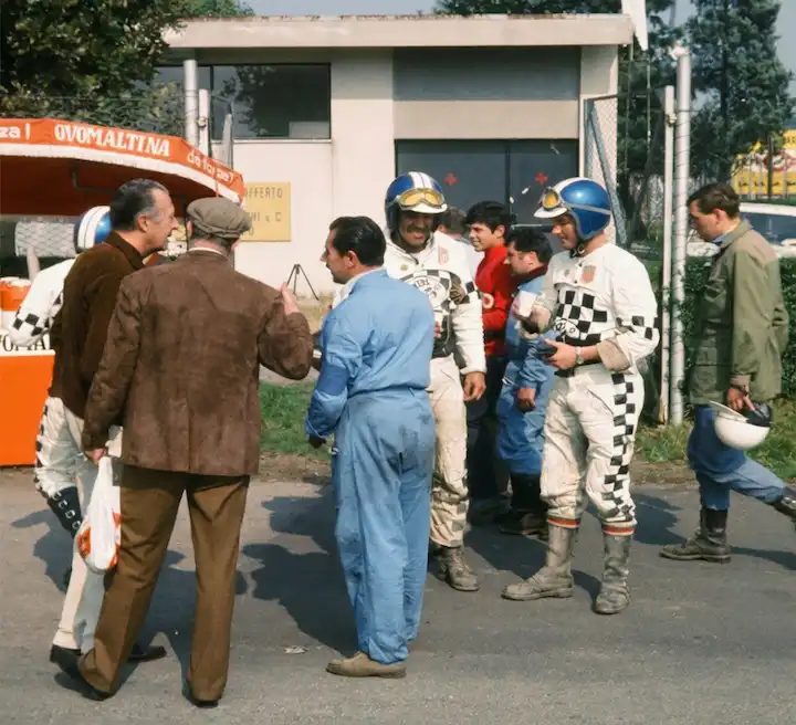 Group of race car drivers and officials chatting
